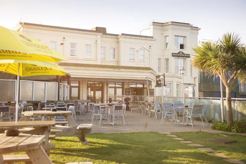 a patio with tables and chairs and a building at Great Western in Newquay