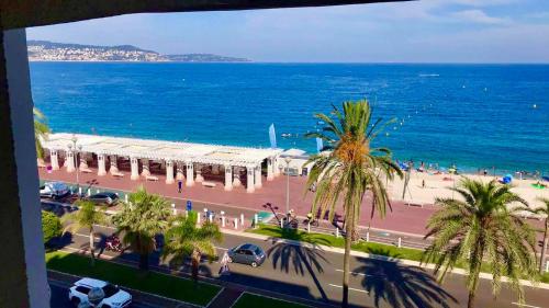 a view of a beach with palm trees and the ocean at A charming corner on the Promenade des Anglais in Nice