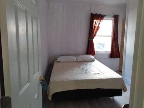 a small bedroom with a bed and a window at Healing Touch Holistic Living Space in Amherst