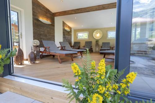 a lobby with chairs and tables on a wooden floor at Seilers Vintage Hotel & Spa in Kandersteg