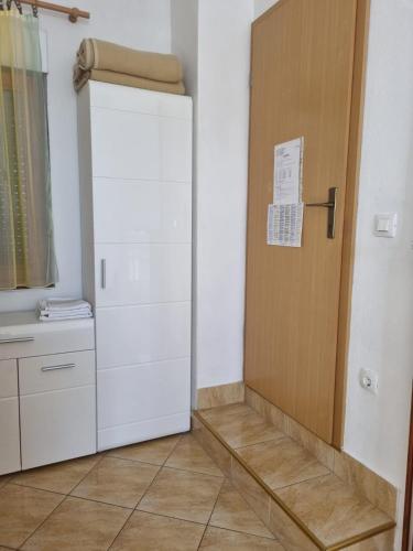 a white refrigerator in a kitchen with a door at APARTMANI TONI POCE 2 in Primošten
