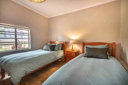 a bedroom with two beds and a window at Tequila Sunrise Cottage at Karoofontein Guest Farm in Geelwal