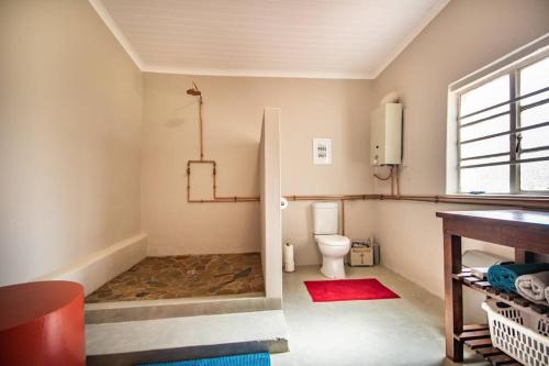 a bathroom with a toilet and a window at Tequila Sunrise Cottage at Karoofontein Guest Farm in Geelwal