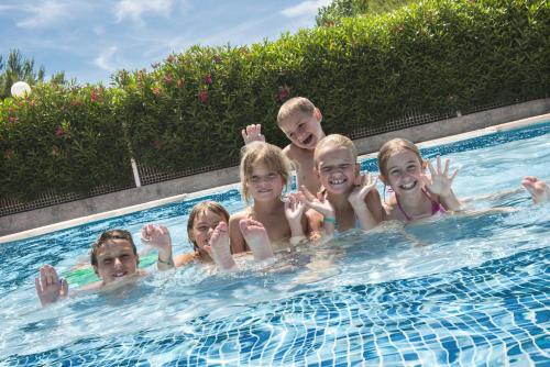 a group of children in a swimming pool at Domaine Les Mûriers in Vendres-Plage