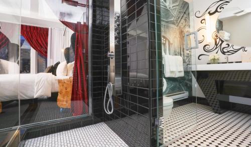 a bathroom with a shower and a bed in a room at Hotel Chez Swann in Montréal