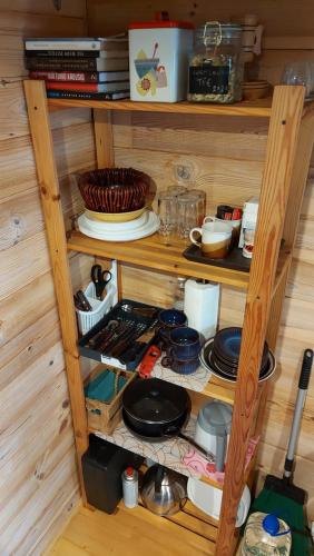 una estantería de madera llena de ollas y sartenes en Intsu cabin ''Marju Kuut'' en Liiva
