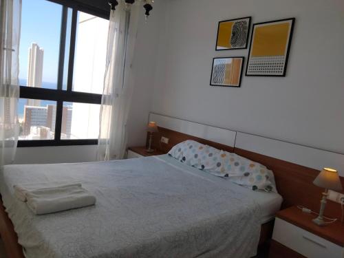 a bedroom with a bed and a large window at Gemelos 26 - Zand Properties in Benidorm