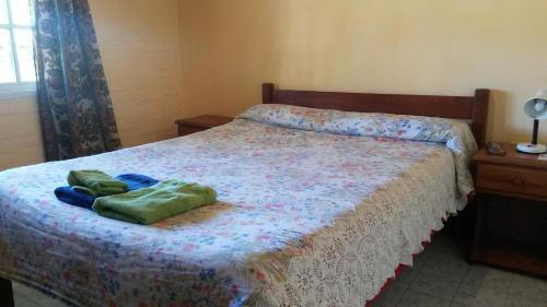 a bedroom with a bed with two towels on it at Posada Los Balnearios in San Pedro