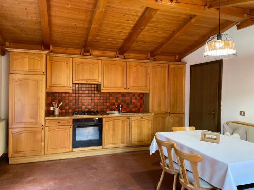 a kitchen with wooden cabinets and a white table with chairs at Chalet Forciagn in San Vigilio Di Marebbe