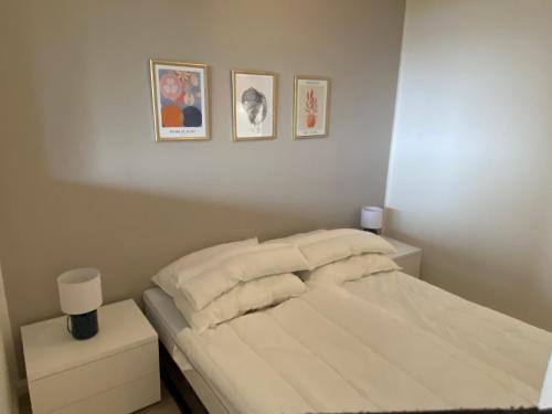 a bedroom with a bed and three pictures on the wall at Moderne 3-Zi-Wohnung mit Meerblick direkt am Strand in Scharbeutz