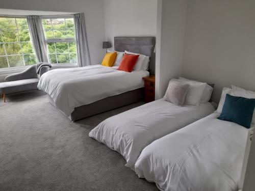 1 dormitorio con 2 camas y ventana en Bosloe en Helston
