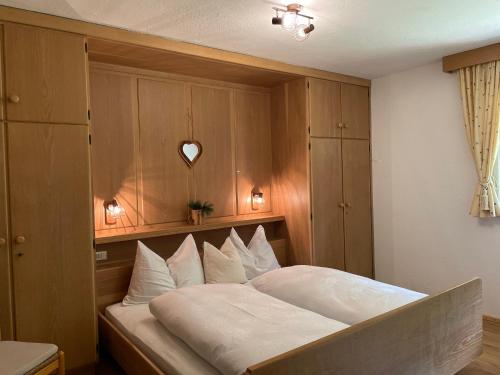 a bedroom with a large bed with a wooden headboard at Chalet Forciagn in San Vigilio Di Marebbe