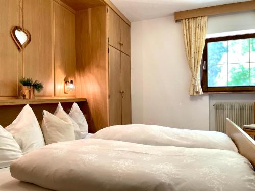 a bedroom with a large bed with white pillows at Chalet Forciagn in San Vigilio Di Marebbe