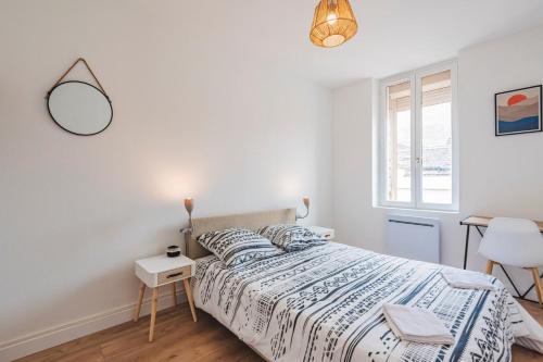une chambre blanche avec un lit et un miroir dans l'établissement Le Majorelle - 2 chambres - Centre Gare, à Reims