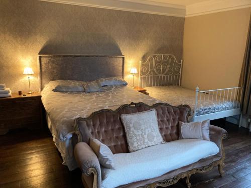 a bedroom with a large bed and a couch at Penyvoel Hall in Llanymynech