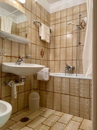 a bathroom with a sink and a tub and a toilet at Chalet Forciagn in San Vigilio Di Marebbe