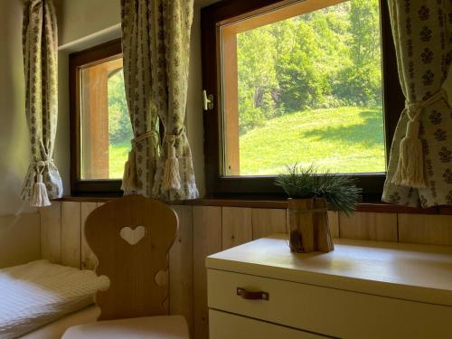 a room with a window with a chair and a table at Chalet Forciagn in San Vigilio Di Marebbe