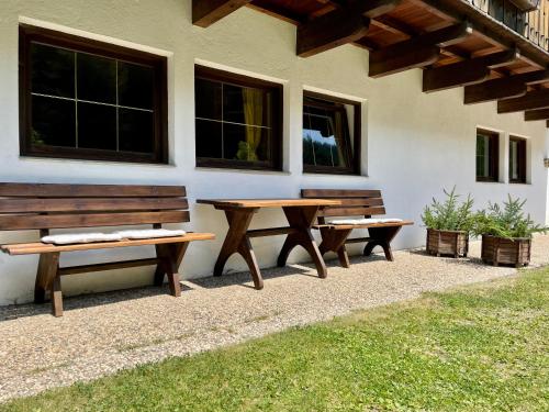 two benches and a table in front of a building at Chalet Forciagn in San Vigilio Di Marebbe