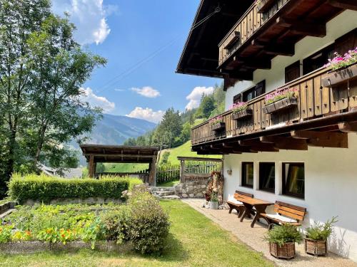 a building with a bench and a balcony with flowers at Chalet Forciagn in San Vigilio Di Marebbe