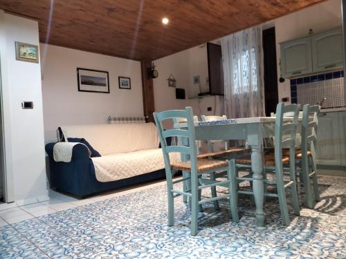 ガエータにあるL'Ancorotto Azzurroのテーブル、椅子2脚、ベッド1台が備わる客室です。