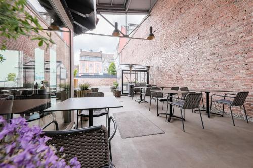 a restaurant with tables and chairs and a brick wall at Hotel Alte Redaktion in Gevelsberg