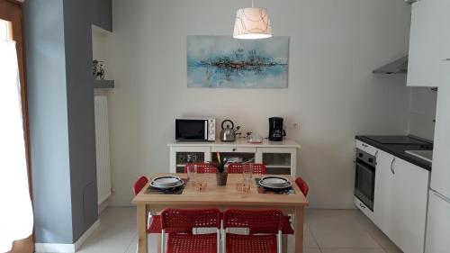 a kitchen with a wooden table and red chairs at Sarca Riverside in Arco