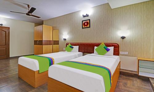 a hotel room with two beds and a tv at Treebo Akshaya Mayflower Vijaya Bank Layout in Bengaluru