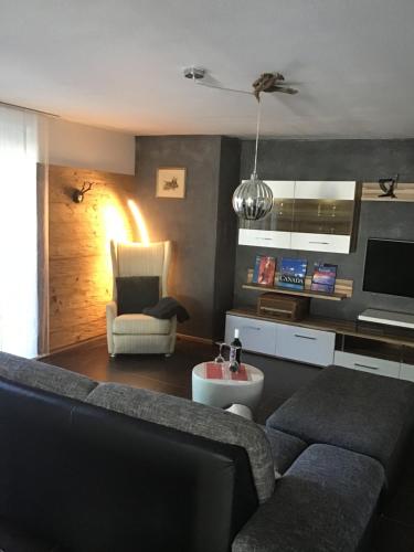ein Wohnzimmer mit einem Sofa und einem Stuhl in der Unterkunft Ferienwohnung Lechraum in Waal in Waal