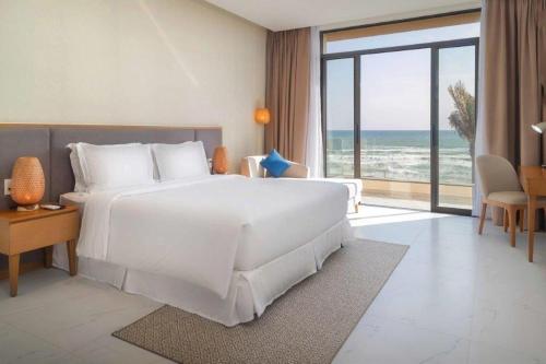 a bedroom with a white bed and a view of the ocean at Sea view villa in Wyndham Garden Cam Ranh in Nha Trang