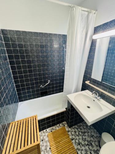 a blue tiled bathroom with a sink and a tub at Cloud 9 , Apartment mit Garage und Garten in Nähe der Uniklinik, Bosch, Ina Schaeffler in Homburg