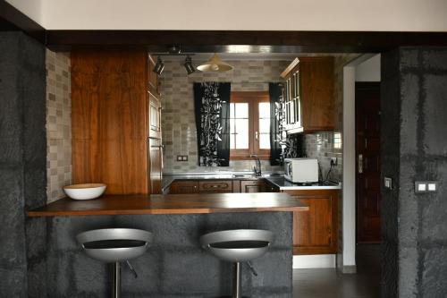 a kitchen with a counter and stools in it at Apartamento Playa Jablillo in Costa Teguise
