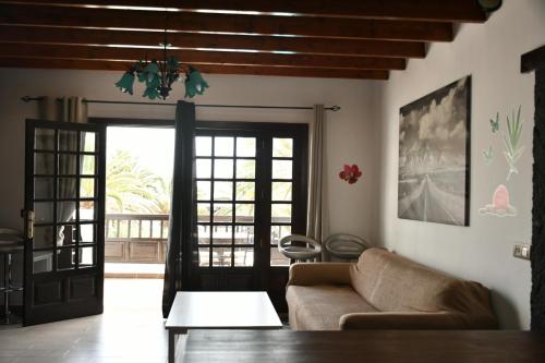 a living room with a couch and a glass door at Apartamento Playa Jablillo in Costa Teguise