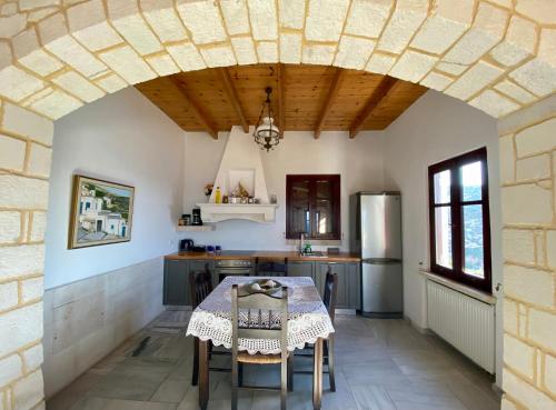 a kitchen with a table with chairs and a ceiling at Stonehouse villas with breathtaking view in Sitia