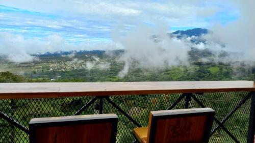 a view from the top of a mountain with clouds at Cabañas El Parador in Boquete