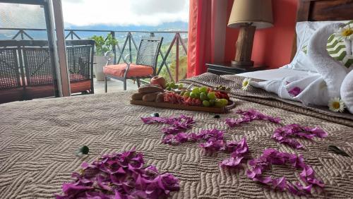 Una cama con una bandeja de fruta y flores. en Cabañas El Parador en Boquete
