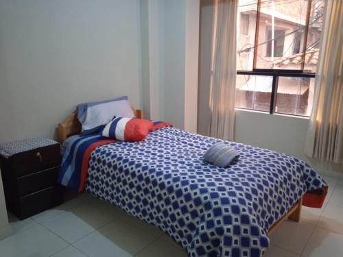 ein Schlafzimmer mit einem Bett in einem Zimmer mit einem Fenster in der Unterkunft La casa de Chepita in Cusco