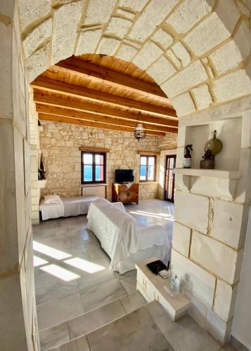 a large room with two beds and a stone wall at Stonehouse villas with breathtaking view in Sitia