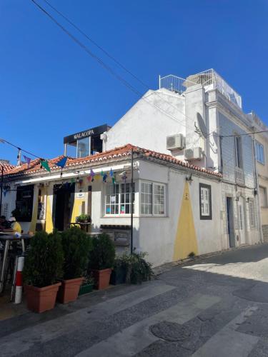 a white building with plants in front of it at Beach House Old Town in Cascais