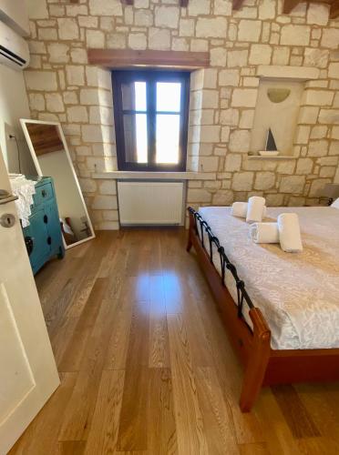 a bedroom with a bed and a brick wall at Stonehouse villas with breathtaking view in Sitia
