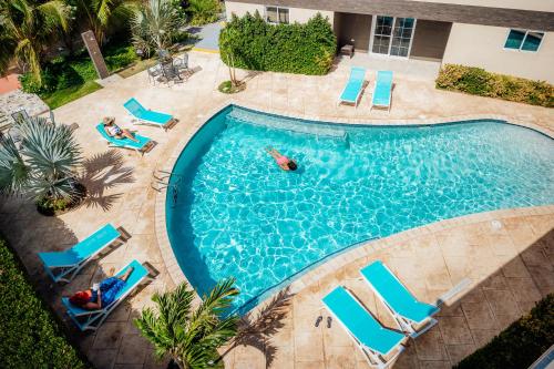 een uitzicht over een zwembad met mensen in het water bij RH Boutique Hotel Aruba in Oranjestad