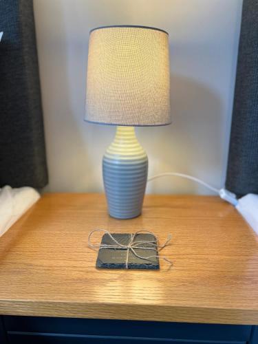 a lamp on a table with a box on it at Sparkling Space - Twin or King Beds in Bangor