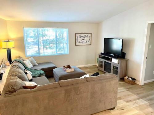 a living room with a couch and a flat screen tv at Yosemite Escapes - Pine Mountain Lake in Groveland
