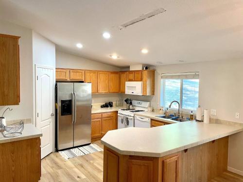 a kitchen with wooden cabinets and a stainless steel refrigerator at Yosemite Escapes - Pine Mountain Lake in Groveland