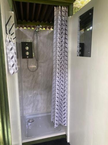 W łazience znajduje się prysznic z zasłoną prysznicową. w obiekcie Eakley Manor Farm Glamping w mieście Newport Pagnell