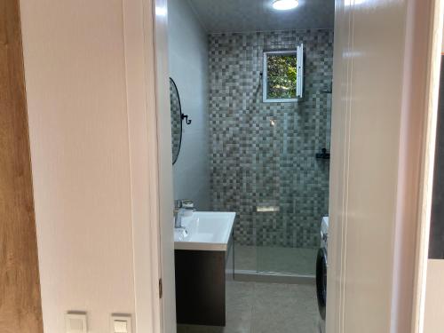 a bathroom with a sink and a shower at OrAnge villa in Gonio