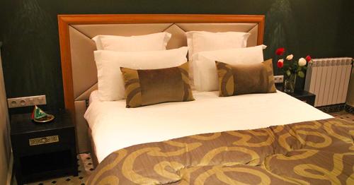 a bedroom with a large bed with white sheets and pillows at Dar Souran in Tangier