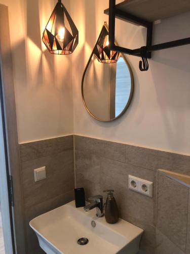 een badkamer met een wastafel en een spiegel bij Apartment Im Sand in Bad Schonborn