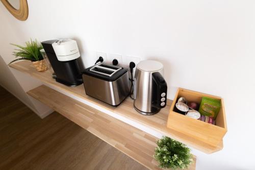 a shelf with a coffee maker and a coffeemaker at La Terrasse du Palais in Avignon