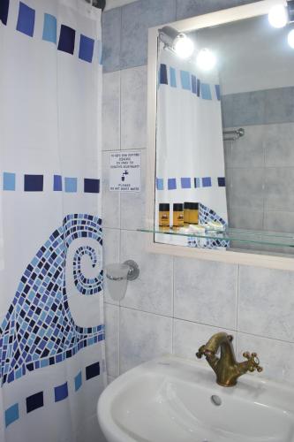 a bathroom with a sink and a mirror at Aegean Star Hotel in Karavostasi