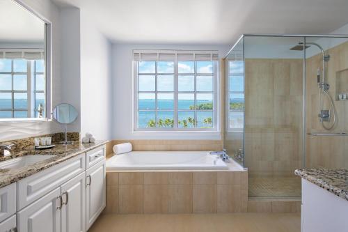 ein Bad mit einer Badewanne, einer Dusche und einem Fenster in der Unterkunft The Westin Cape Coral Resort at Marina Village in Cape Coral